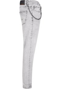 Jeans skinny en denim gris clair avec une finition délavée, présentant un accent chaîne sur la ceinture et des poches standards à l'arrière.