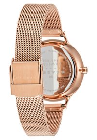 Reloj con correa de malla en oro rosa, con una caja redonda, esfera plateada y detalles grabados en la parte posterior. El cierre lleva el nombre de la marca.