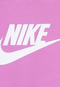 Pinkfarbener Stoff mit einem großen weißen "NIKE"-Logo und einem Swoosh-Design. Das Material wirkt glatt und leicht strukturiert.
