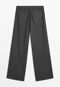 Donkergrijze wijde broek met verticale witte krijtstrepen, elastische tailleband en twee achterzakken. Glad oppervlak en op maat gemaakte ontwerp.