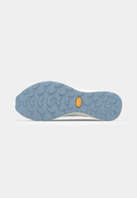 Trail running shoe outsole with a textured blue rubber surface, featuring a yellow Vibram logo and triangular tread patterns for grip.