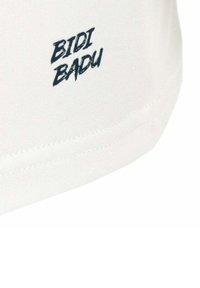 Camiseta blanca de tela con el logo "BIDI BADU" en color azul marino impreso en el dobladillo. Textura suave con corte recto. Sin patrones ni acentos adicionales.