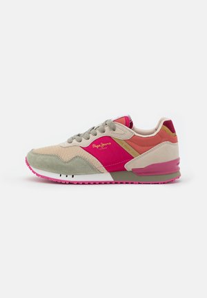 Low-top sneaker med beige mesh, lyserøde ruskind detaljer, grå snørebånd og brandet tekst på siden, placeret mod en hvid baggrund.