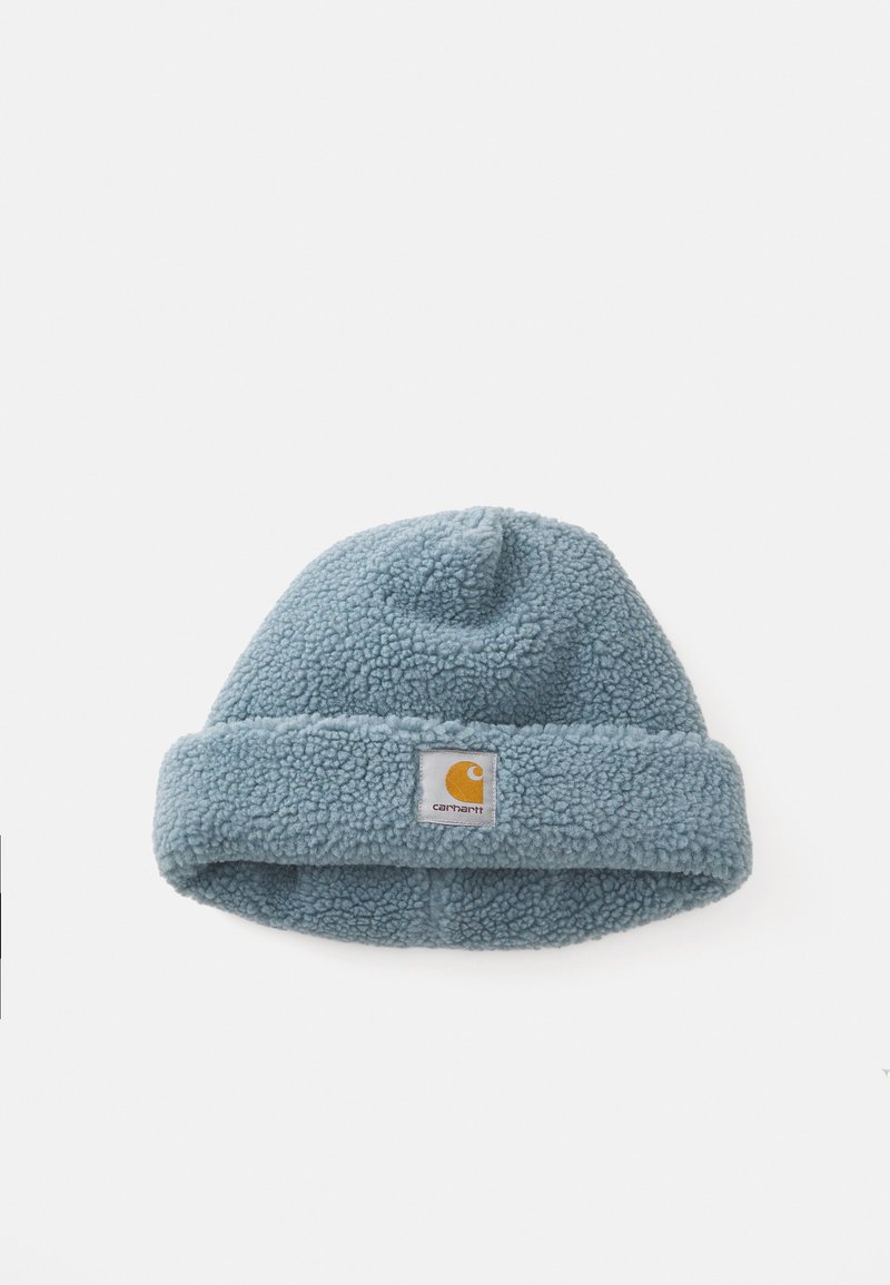 Blauwe fleece muts met een omgekrulde rand, voorzien van een vierkant label met een oranje logo. Zachte textuur en ronde bovenkant met een lichte piek.
