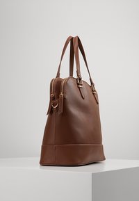 Brown leather tote bag with a textured finish, double zip closure, and gold-tone hardware, featuring two top handles and a structured design.