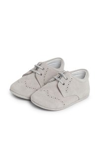 Scarpe in suede grigio con punte tonde, presentano perforazioni decorative sulla parte frontale e sui lati, e lacci grigi. Progettate per comfort e facilità d'uso.