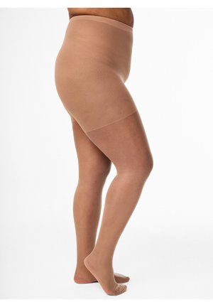 Vrouw die huidkleurige transparante panty draagt, staand op haar tenen tegen een effen witte achtergrond, waarbij de pasvorm van haar been en heup wordt getoond.