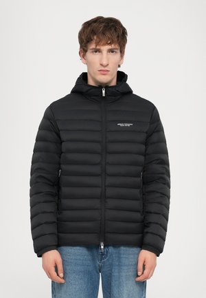 Veste en duvet noire avec fermeture éclair à l'avant et capuche amovible. Design matelassé horizontal et petit logo sur la poitrine. Comprend des poches sur les côtés.