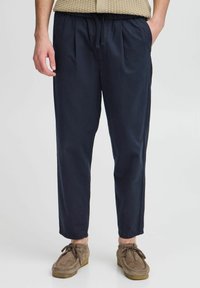 Navy blue, lightweight trousers with a relaxed fit, featuring an elastic waistband, side pockets, and a smooth texture.