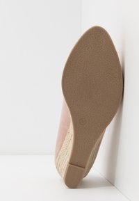 Roze suede wedge schoen met een getextureerde beige touwaccent. De zool is glad en bruin, gemarkeerd met de maat 37.
