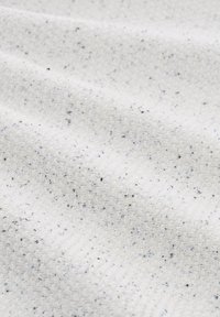 Tissu texturé en blanc avec des éclats noirs et bleus, présentant un motif tissé et une teinte douce, blanc cassé. Idéal pour la couture ou l'ameublement.