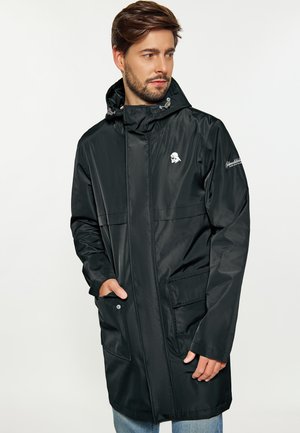 Pelerină de raincoat neagră, rezistentă la apă, cu glugă, dotată cu două buzunare frontale, închidere cu capse și un logo discret pe piept și pe mânecă.