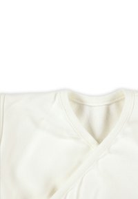 Weißes V-Ausschnitt-Oberteil aus weichem, strukturiertem Stoff. Besitzt überlappende Vorderpaneele und eine gerippte Ausschnitt-Detailierung.