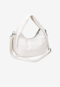 Bolso de piel blanca con textura de piedras, con forma curva, un asa en la parte superior y una correa para el hombro desmontable. Presenta un cierre con cremallera y una superficie texturizada.