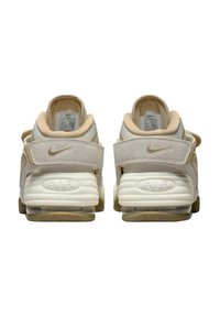 Nike Air-skor har en vit och beige design, läder- och mockamaterial, vadderad krage, synlig luftdämpning och texturerad sula.