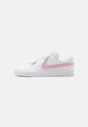 Zapatilla baja blanca con el logo de Nike rosa, tiras blancas de velcro y suela de goma blanca sobre fondo claro y liso.