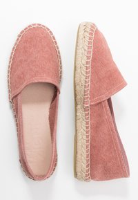 Espadrilles en tissu rose avec une semelle en jute tissée, des panneaux latéraux élastiques et une doublure intérieure lisse. Design à bout rond et couture minimaliste.