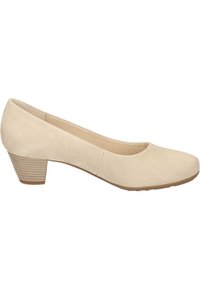 Beige suède pump met een ronde neus en een lage, gestapelde hak met een ribbelpatroon. Glad textuur en een simpele silhouet.