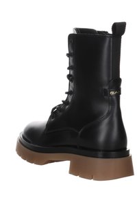 Stivaletto in pelle nera con suola robusta marrone, dotato di lacci e di un linguettino laterale, con un accento del marchio vicino al tallone.