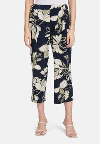 Granatowe kwiatowe spodnie rybaczki z elastycznym paskiem w talii, z dużymi kremowymi i oliwkowymi nadrukami roślinnymi oraz miękką, gładką teksturą.