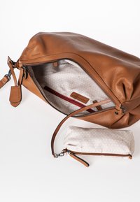 Borsa a mano in pelle marrone con cerniera aperta che mostra un interno beige a fantasia e una pochette beige abbinata con un tiragno in pelle.