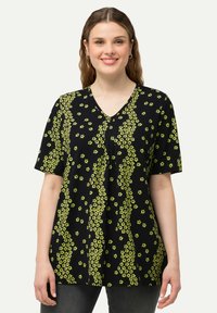 Černá halenka s krátkým rukávem a žlutým květinovým vzorem, s výstřihem do V, uvolněný střih, s malými sklady v přední části pro dodatečný detail.