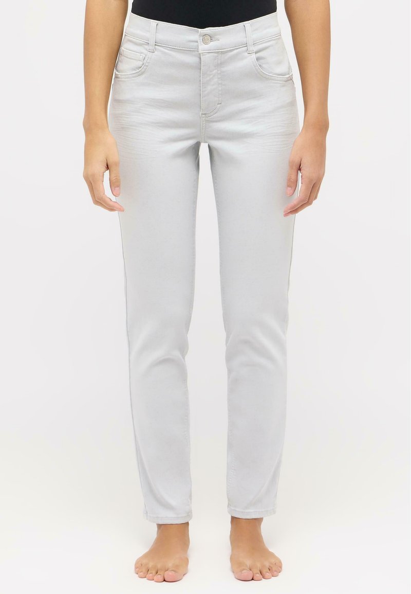Jean gris clair avec une coupe slim, design à cinq poches et fermeture à bouton. Les coutures visibles et la texture subtile mettent en valeur le tissu.
