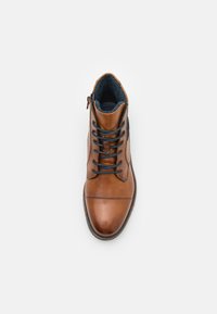 Bota de cuero marrón con puntera redonda, cordones negros y forro de tela azul. Cuenta con una cremallera en el lateral y una suela texturizada.