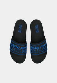 Sorte slidesandaler med teksturert gummioverflate, med en blå stropp med logo som tydelig viser "VERSACE JEANS COUTURE".