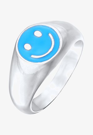 Sølvfarvet ring med et blåt smiley-ansigt design på en glat, rund overflade, med en poleret finish og ingen synlige mønstre eller accenter.