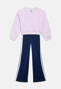 Λιλά κοντό φούτερ με λογότυπα Adidas και Disney, συνδυασμένο με μπλε σκούρο παντελόνι με φαρδιά μπατζάκια και λευκές λωρίδες στο πλάι, απλωμένα επίπεδα.