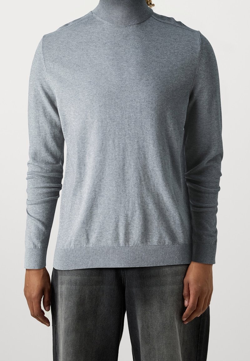 Maglione grigio con dolcevita realizzato in morbido tessuto a maglia, caratterizzato da maniche lunghe, un colletto aderente e dettagli a costine sull'orlo. Design minimalista.