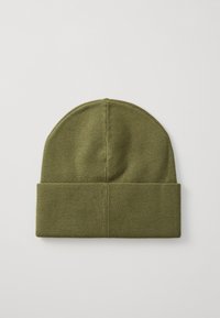 Berretto di maglia verde oliva con risvolto a coste, texture liscia e parte superiore arrotondata. Il materiale appare morbido e flessibile.