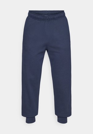 Marineblå joggingbukser lavet af blødt stof med elastisk talje og ribbede manchetter. Enkelt design uden mønstre eller detaljer.
