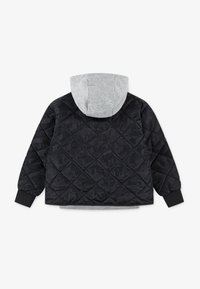 Veste noire matelassée avec une capuche grise. Dotée de poignets élastiques et d'un motif en losanges, faite en matériau synthétique.