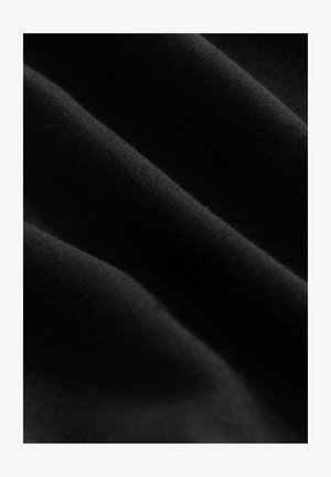 Čierna tkanina s hladkým povrchom, obsahujúca jemné záhyby a vrásky. Rovnomerné rozloženie farby bez vzorov alebo viditeľného hardvéru.