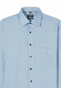 Hellblaues Hemd mit Knopfleiste, kleinen schwarzen Punkten, modernem Schnitt, langen Ärmeln und einer Brusttasche auf der linken Seite.