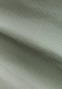 Texturiertes Gewebe in gedämpftem Grün, mit einem gerippten Muster aus feinen Linien, glatter Oberfläche und leichtem Glanz. Ideal für verschiedene Anwendungen.