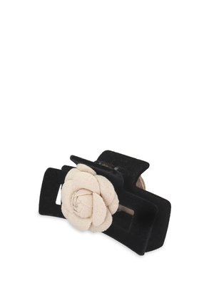 Schwarze Haarklammer mit einer strukturierten, floralen beige Akzent. Die Klammer hat eine rechteckige Form und eine sanfte, matte Oberfläche.
