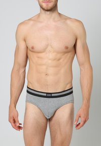 Graue Baumwollunterhosen mit einem schwarz-weißen gestreiften Bund, mit einem klassischen Schnitt und einer weichen Textur. Mit "Jockey"-Label versehen.