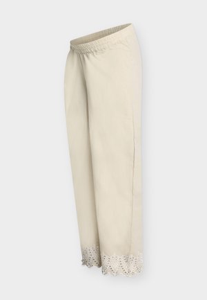 Μπεζ παντελόνια με φαρδιά μπατζάκια, ελαστική μέση και διακοσμητικό δαντελένιο τελείωμα με τρύπες στη βάση, απεικονισμένα πάνω σε απλό φόντο.