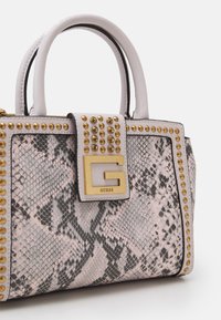 Torebka o wzorze węża w kolorze różowym i szarym, z złotymi ćwiekami i wyraźnym logo. Solidne, podwójne uchwyty oraz usztywniony kształt.