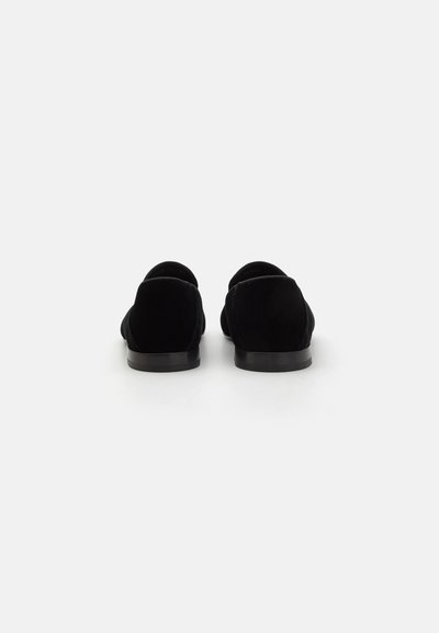 Black suede loafers with a rounded toe design, flat rubber sole, and smooth texture. Simple construction without visible hardware or accents.
