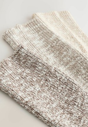 Sæt af tre strikkede sokker i beige og creme farver, med et struktureret mønster og ribbede kanter for komfort.