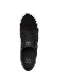 Crne nubuk skate tenisice s niskim dizajnom, s crnim vezicama, podstavljenim ovratnikom i bijelim gumenim potplatom. DC logo vidljiv na ulošku.