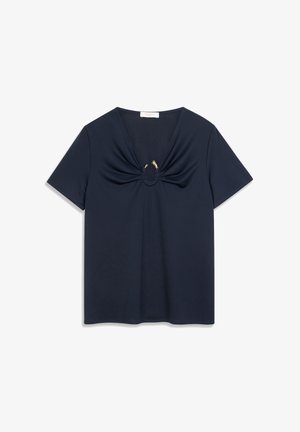 Top azul marino de manga corta con escote en V y detalle de tela fruncida en la parte frontal, con un aro decorativo que incluye dos pequeños elementos adornos.