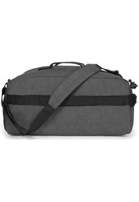 Harmaa duffel-laukku, joka on valmistettu teksturoidusta kankaasta. Siinä on kestävä olkahihna, kahva ja vaakasuuntainen verkkokangaslisä tukea varten.