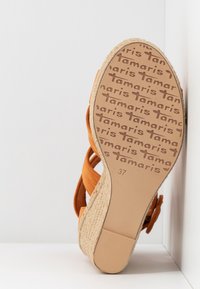 Semelle de sandale à bride en forme de tranche d'orange montrant le motif du logo de la marque Tamaris et la taille 37, avec un talon plateforme en espadrille tressée.