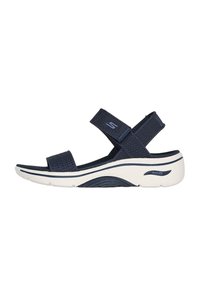 Sandalo blu navy con cinturini in rete, chiusure regolabili con velcro e una suola bianca imbottita con design di supporto per l'arco.
