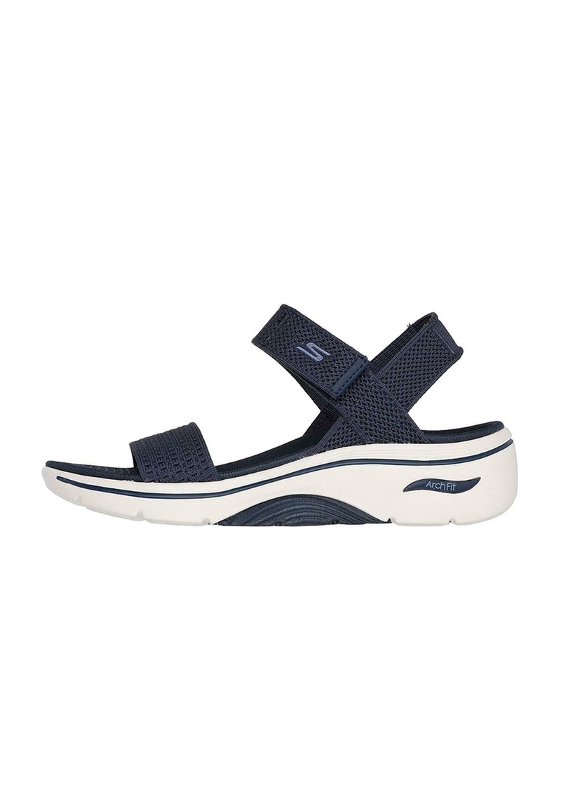 Sandalo blu navy con cinturini in rete, chiusure regolabili con velcro e una suola bianca imbottita con design di supporto per l'arco.